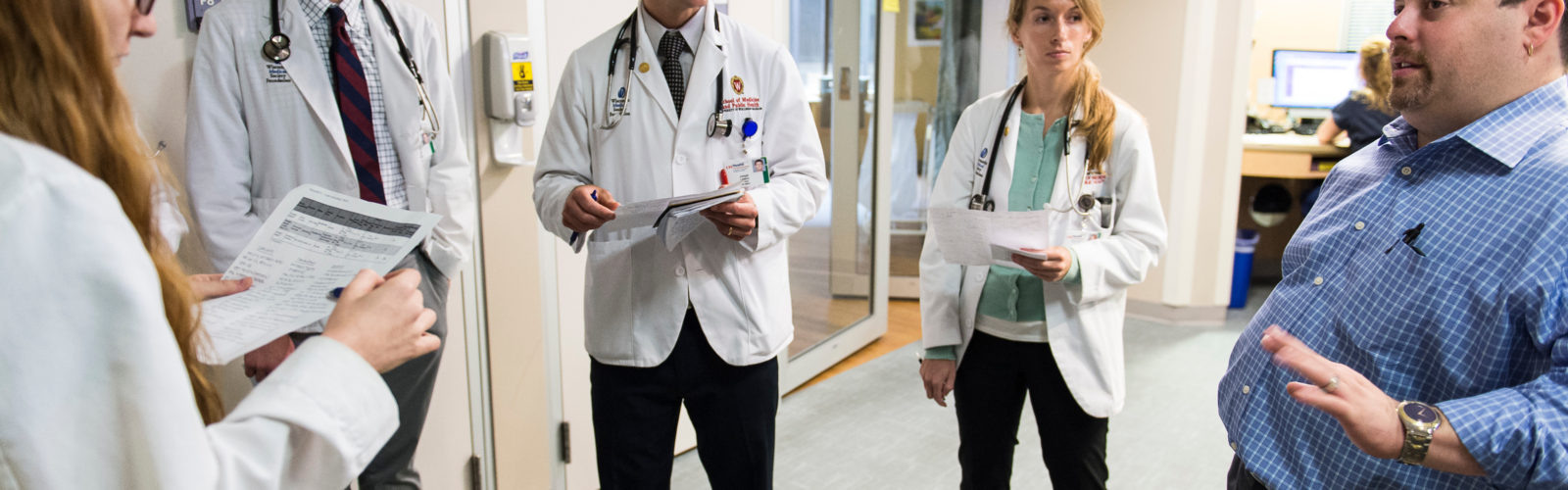 The medical director of the Neurocticial Intensive Care Unit at UW Hospital and Clinics talks to a group of medical students during floor rounds