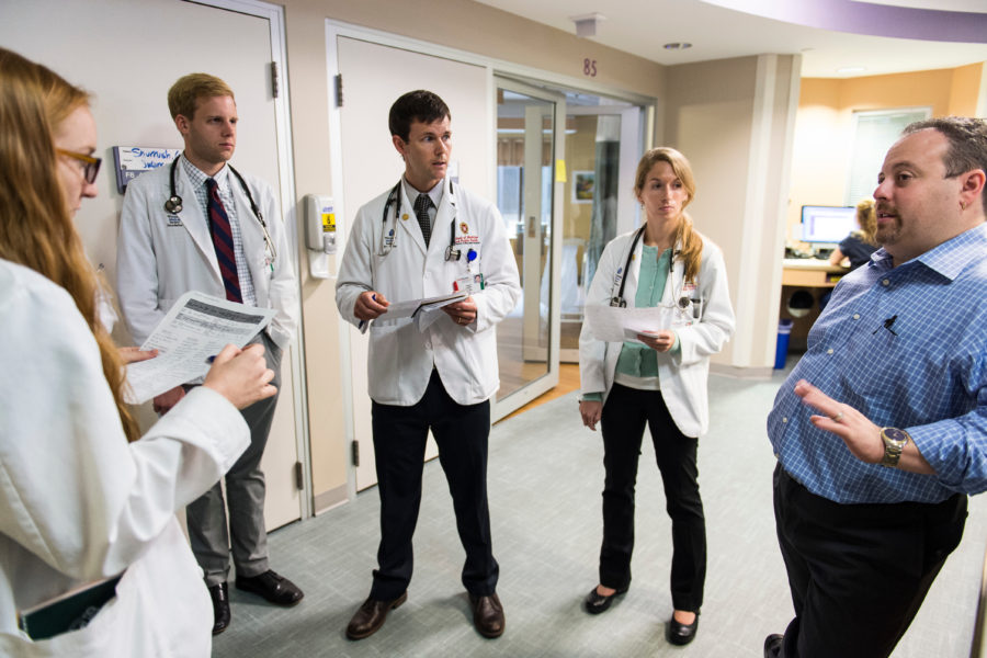 The medical director of the Neurocticial Intensive Care Unit at UW Hospital and Clinics talks to a group of medical students during floor rounds