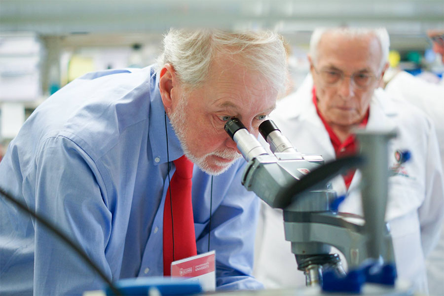 Man looking into a microscope in a UW lab