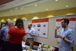 BadgerConnect participants and research service representatives talk in front of the Biotechnology Center Core Services poster.