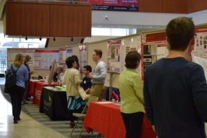 Participants talk to vendors and research services and look at posters.