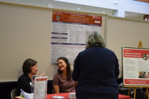 Two staff members from the Wisconsin Alzheimer's Disease Research Center talk to each other and a BadgerConnect participant.
