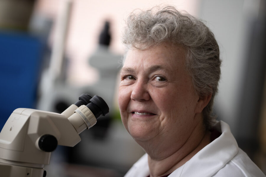 dr. gumperz smiling by a scope