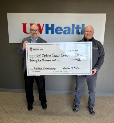 Two men holding a large donation check