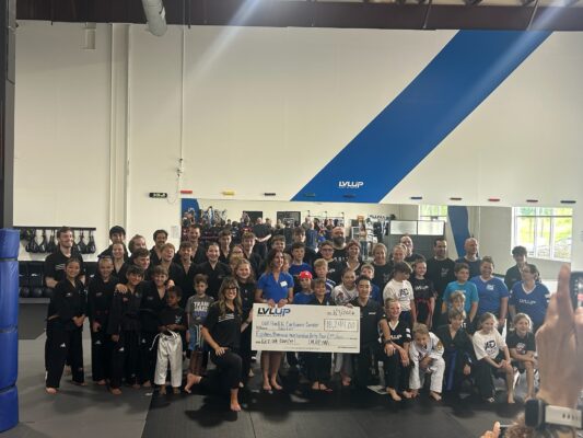 group of people holding a large donation check